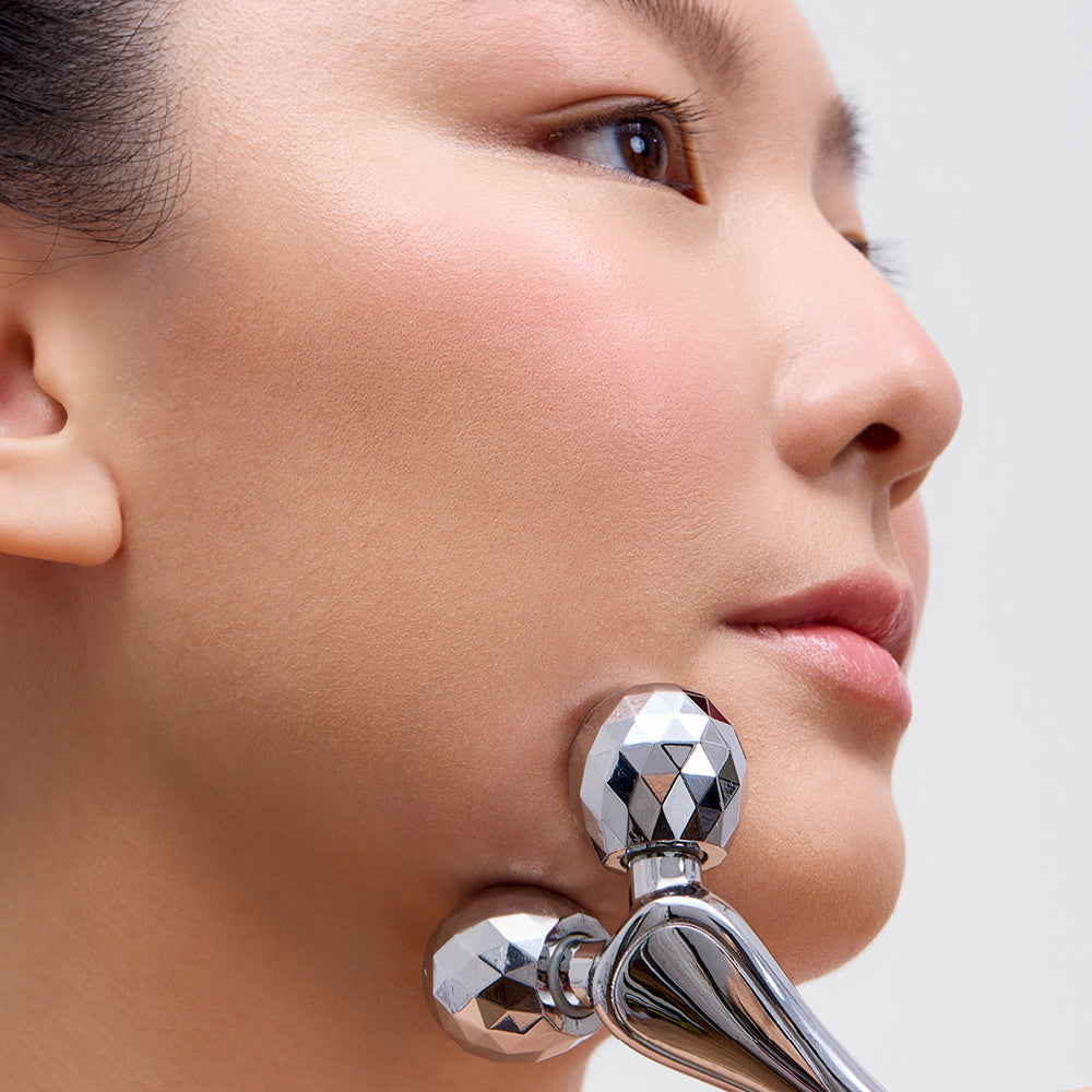 image mood pof model using the contouring facial roller on her jawline