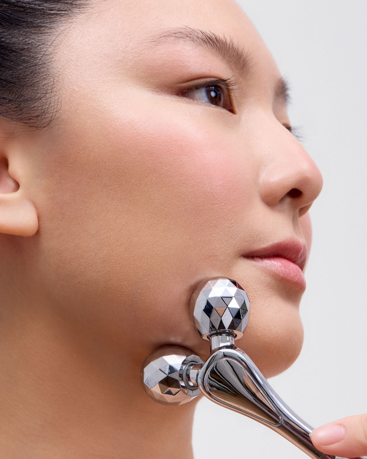image mood of model using the Melume Skinscience's contouring facial roller on her jawline